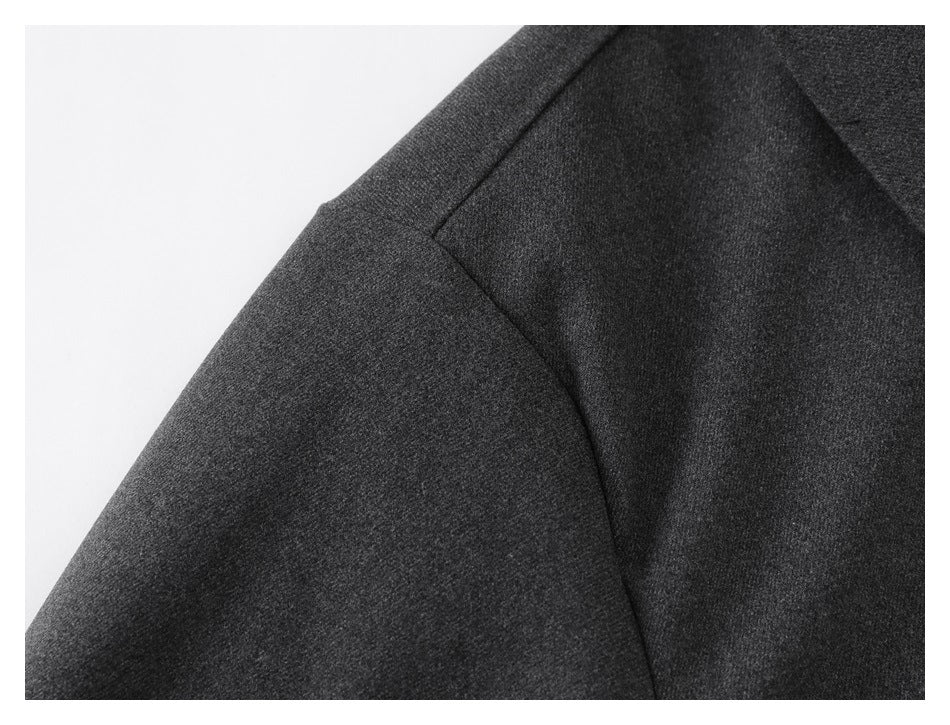 Close-up of the dark charcoal jacket's shoulder seam and sleeve.