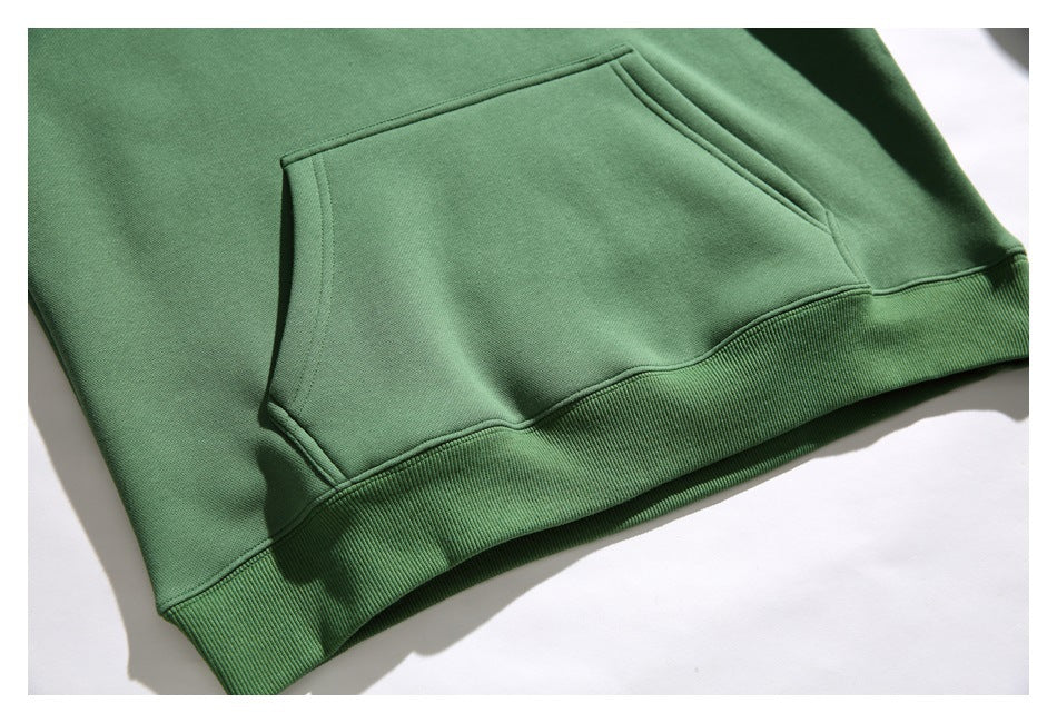 Close-up of the green hoodie’s large kangaroo pocket and ribbed hem.