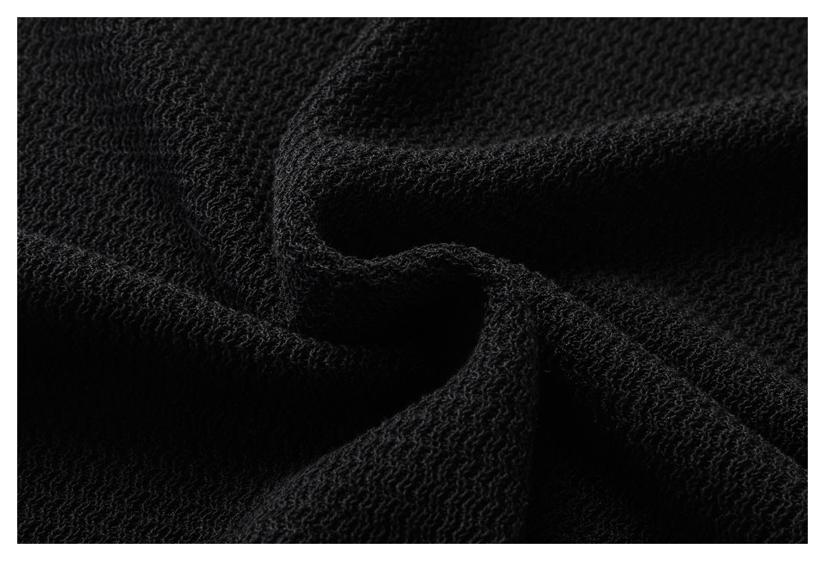 Macro view of the raised, textured knit on a black garment.