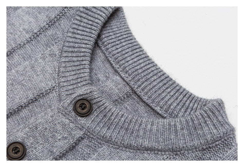 Close-up of a gray knit cardigan neckline with a ribbed collar and dark buttons.