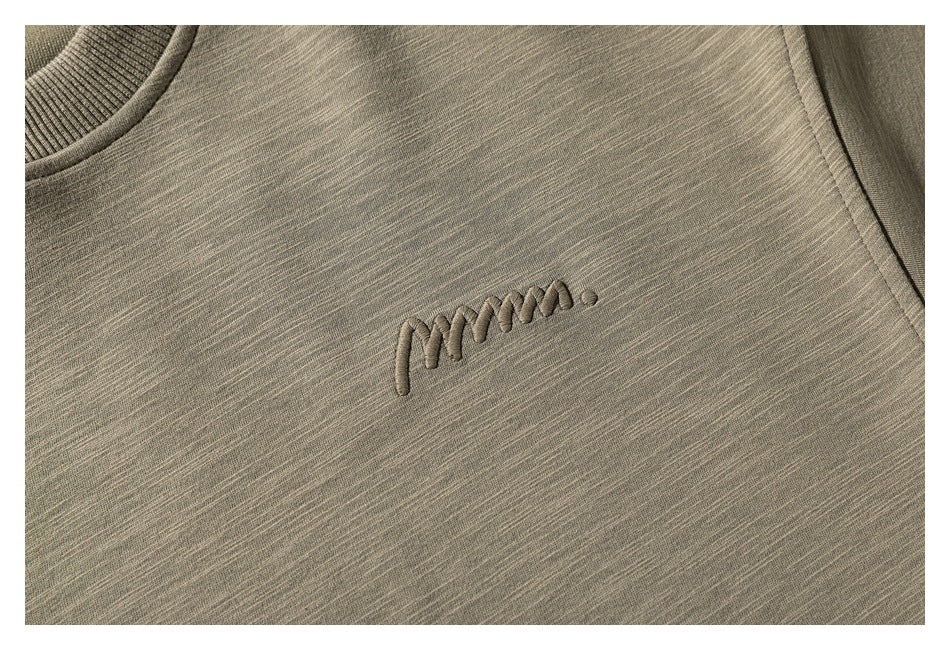 Close-up of tonal raised script embroidery on the olive-gray sweatshirt chest.