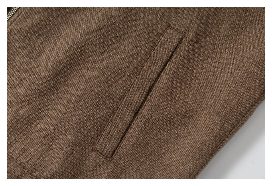 Close-up of a narrow welt pocket on brown textured fabric.