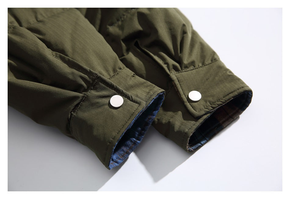 Close-up of olive jacket cuffs with silver snap buttons and plaid lining inside.