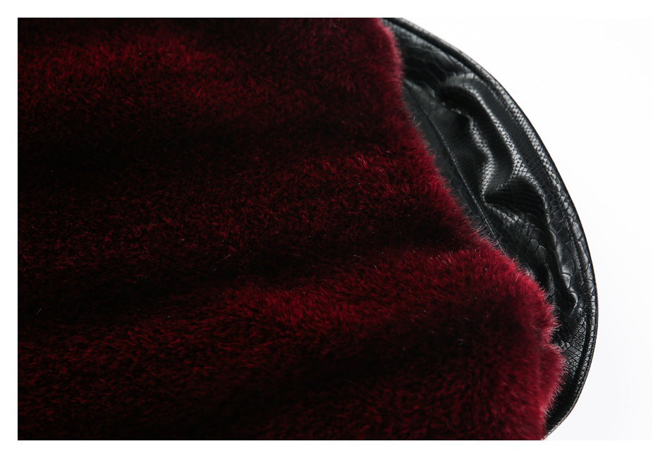 Close-up of burgundy pile beside a curved black reptile-embossed edge.