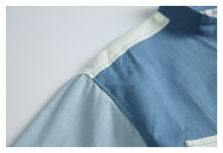 Close-up of the shirt's blue body, pale shoulder panel, and light blue sleeve seam.