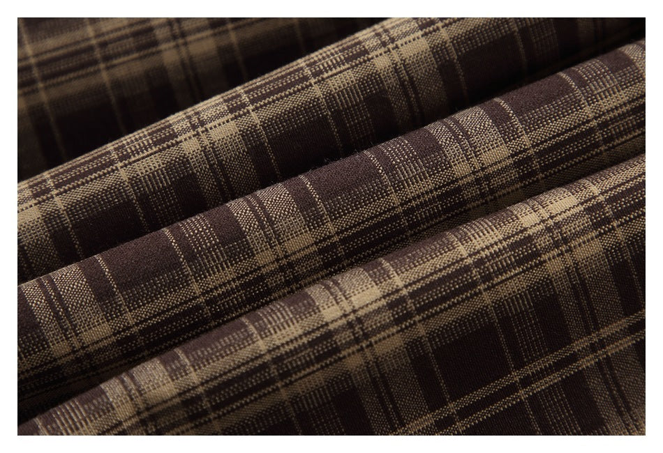 Macro view of the brown and tan plaid fabric texture.