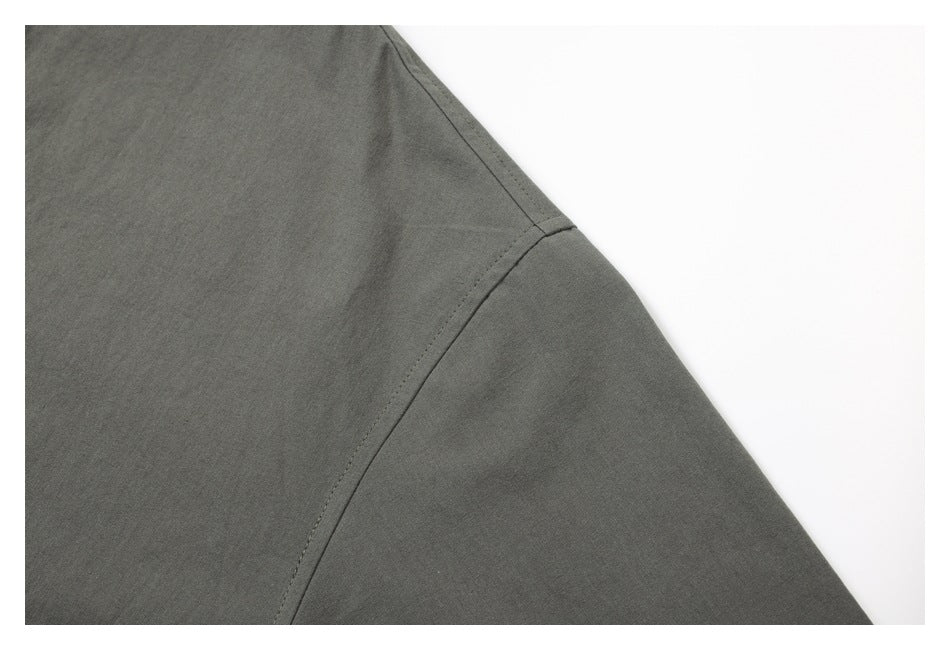 Close-up of the dark gray shirt's shoulder seam and sleeve construction.