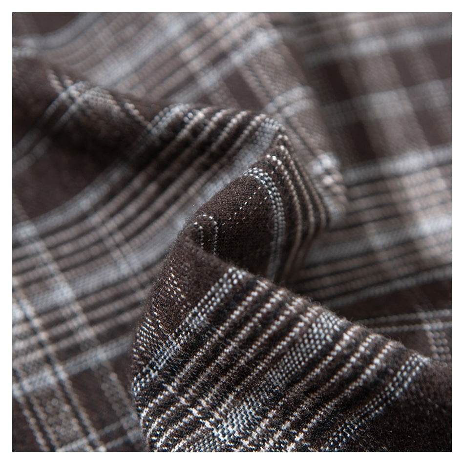 Macro view of the dark brown plaid shirt fabric and stitching.