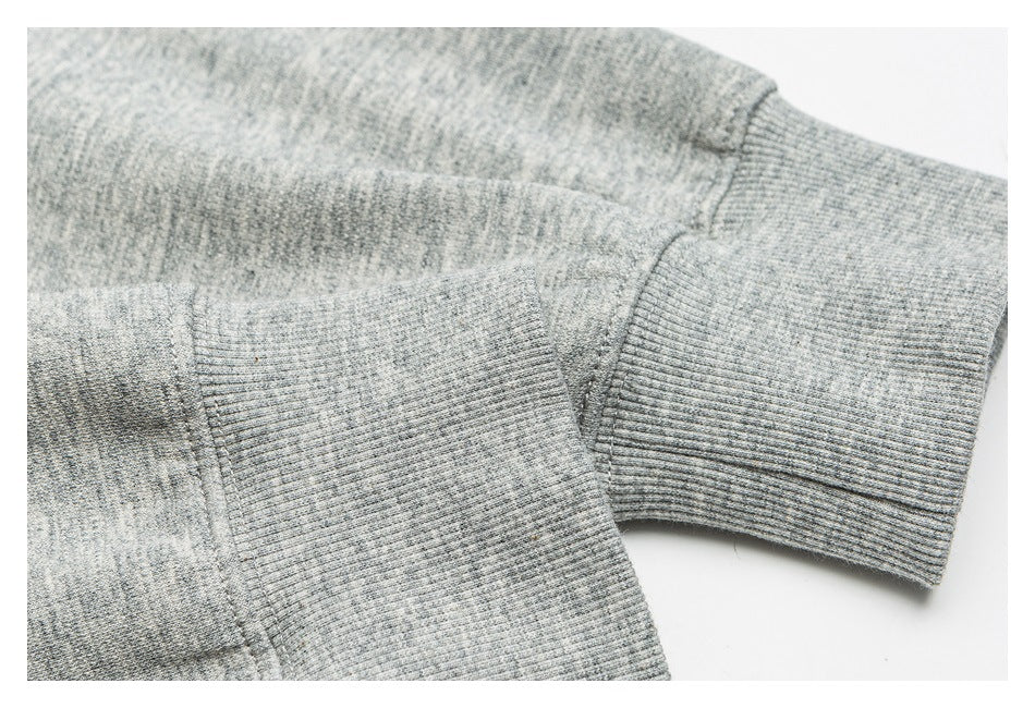 Close-up of a gray marl knit garment with ribbed cuffs and visible seams.