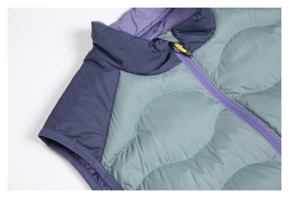 Close-up of the garment neckline and shoulder, with blue-gray quilting, navy panels, and a purple zipper.