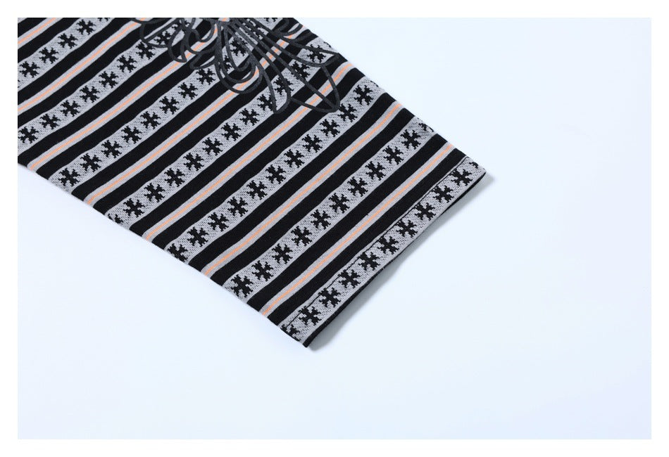 Close-up of a finished hem on gray, black, and peach striped garment fabric.