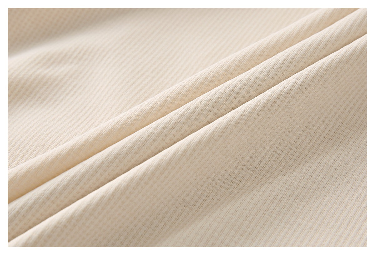Close-up showing the fine textured surface of cream fabric in soft folds.