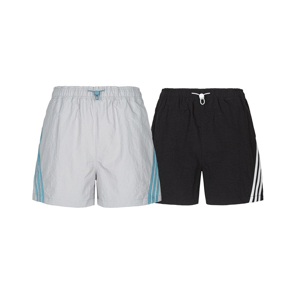 Front views of gray shorts with blue side stripes and black shorts with white side stripes.