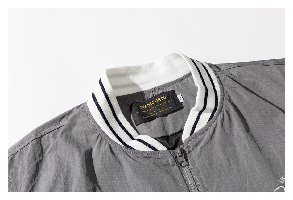 Close-up of the gray jacket's striped rib collar, zipper, and sewn neck label.