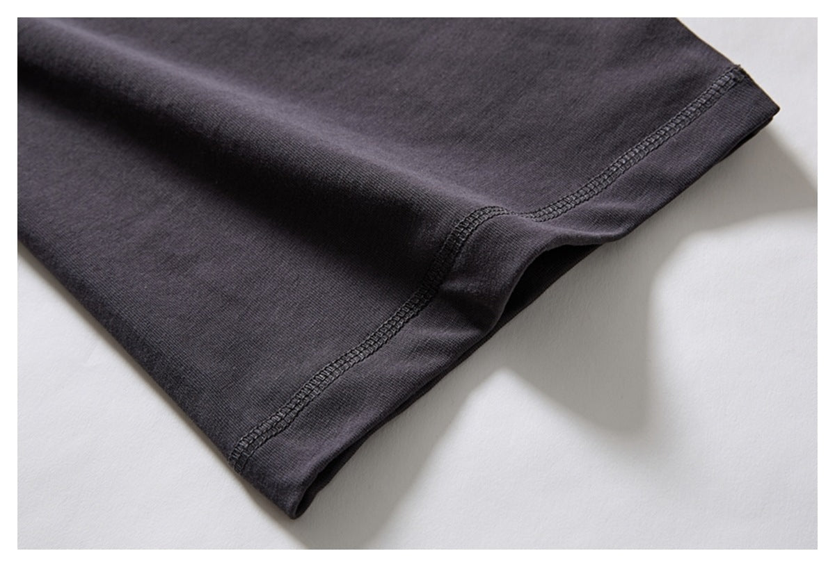Close-up of the charcoal garment sleeve cuff with visible dark overlock stitching.