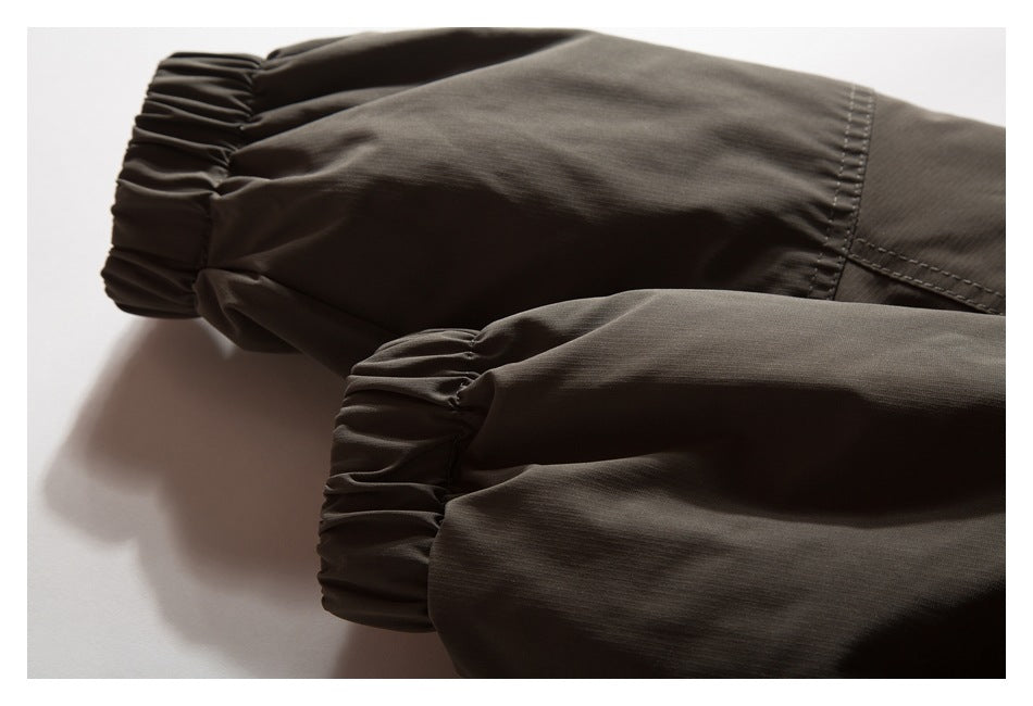 Close-up of two dark taupe jacket sleeves with gathered elastic cuffs.