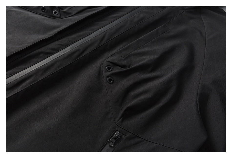 Close-up of a black jacket with a diagonal zipper, snap fasteners, and a flap pocket.