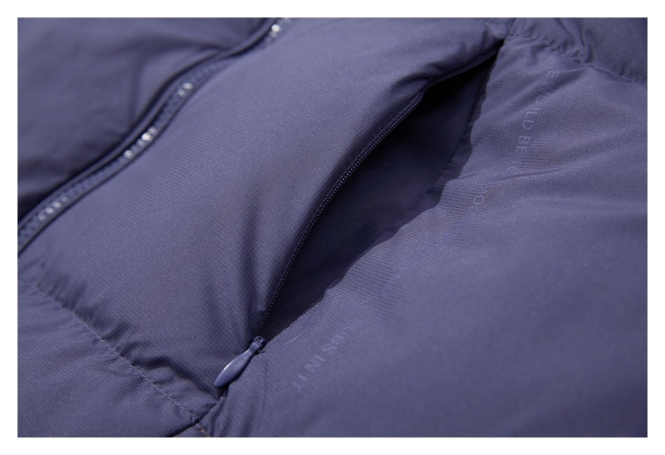 Close-up of a slate-blue garment zipper and open pocket, with faint English text on the fabric.