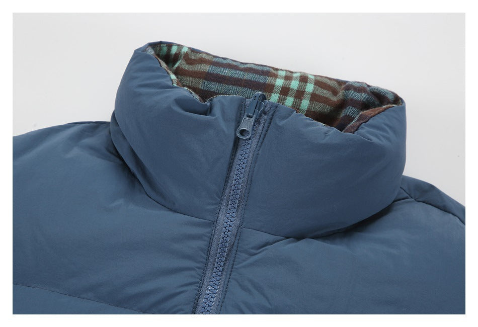 Close-up of a slate-blue padded jacket collar, plaid lining, and front zipper.