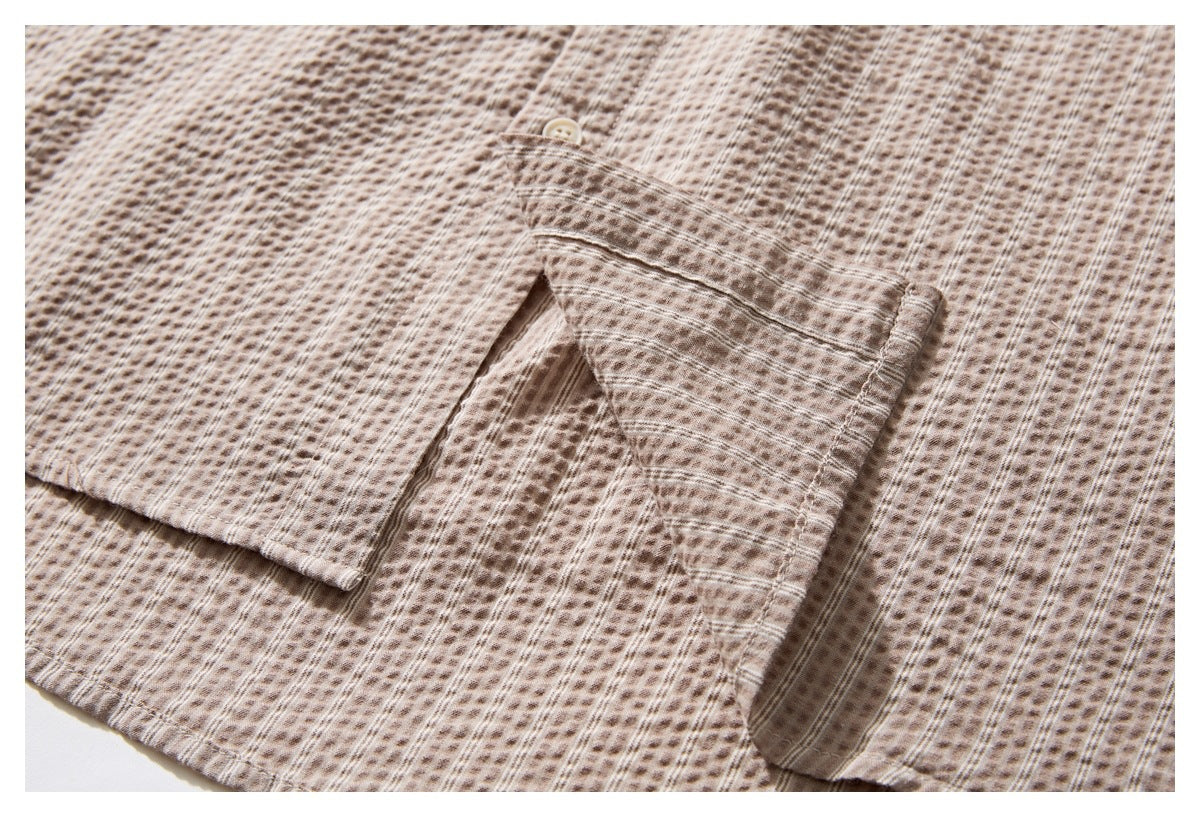 Close-up of the shirt hem and side seam on beige-brown patterned fabric.