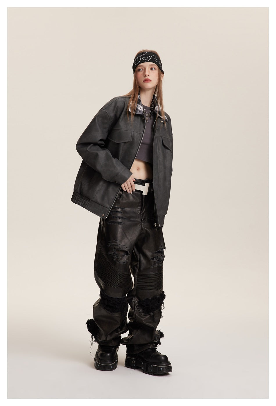Angled view of a model wearing an open charcoal-gray jacket with a plaid collar and flap chest pockets.