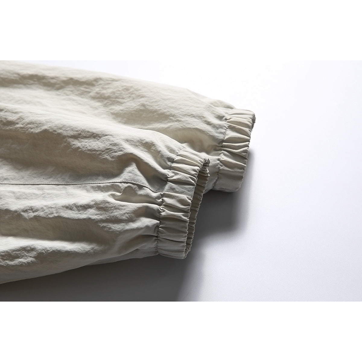 Close-up of the off-white jacket's sleeves ending in gathered elastic cuffs.