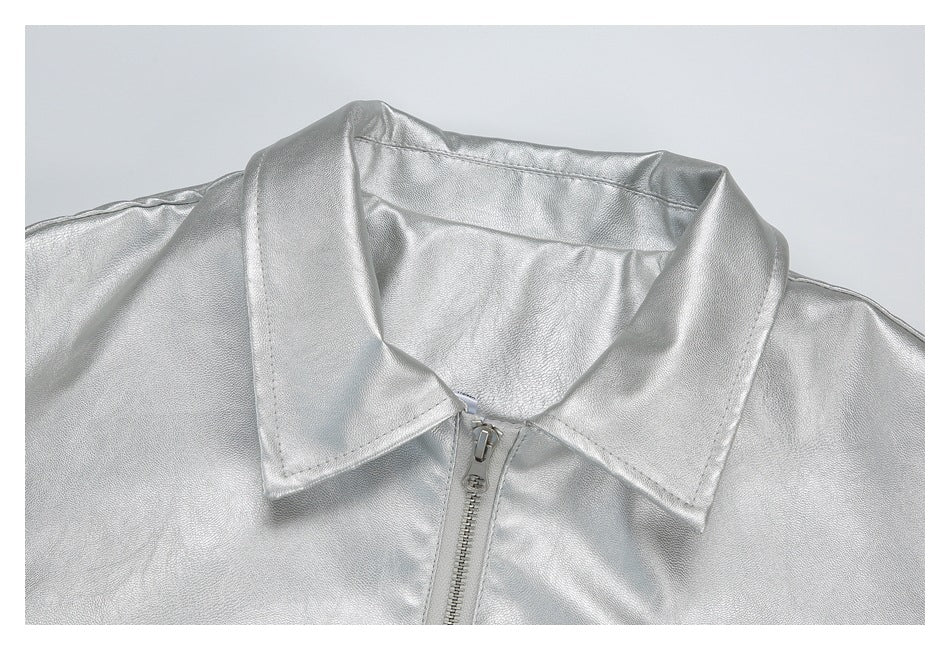 Close-up of a silver jacket's pointed collar and front zipper.