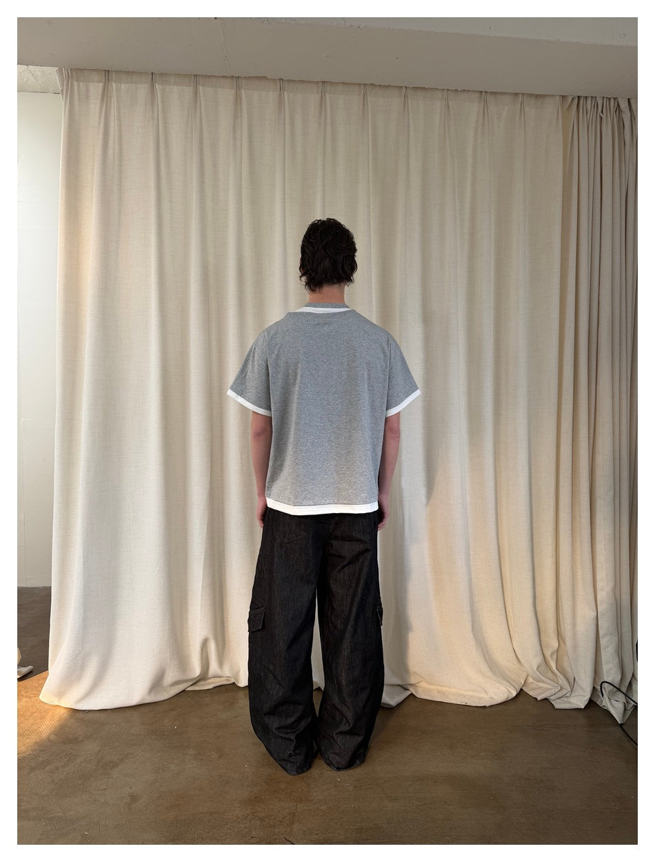 Rear view of a model wearing a plain gray short-sleeve T-shirt with white trim at the collar, sleeves, and hem.