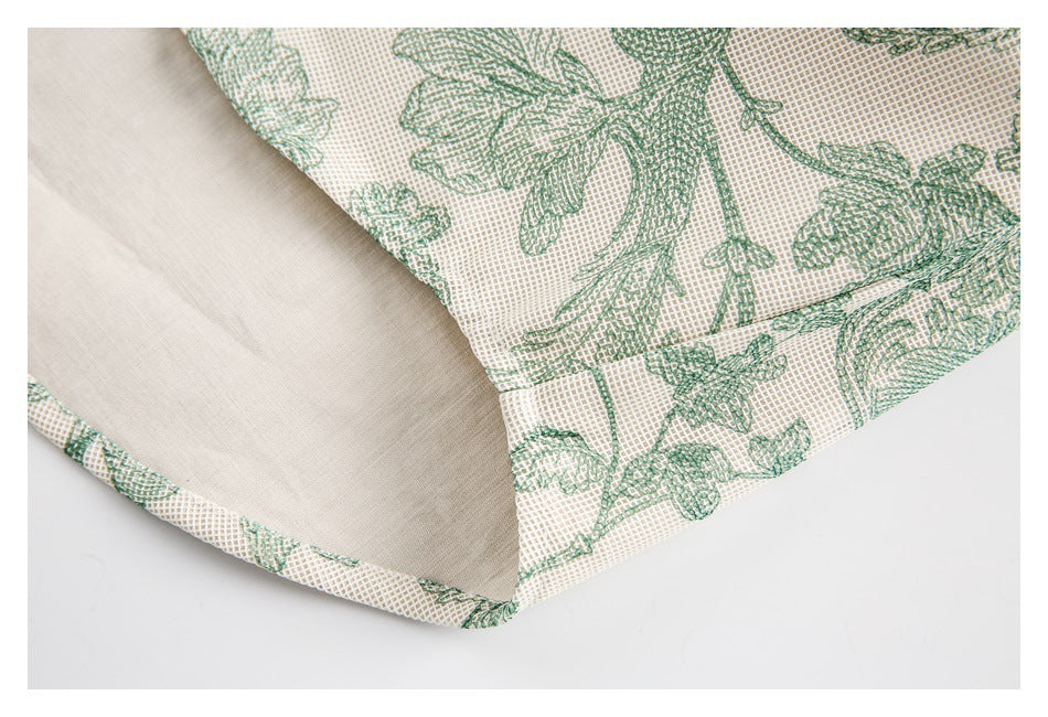 Close-up of a seam joining cream fabric with green floral-patterned fabric.