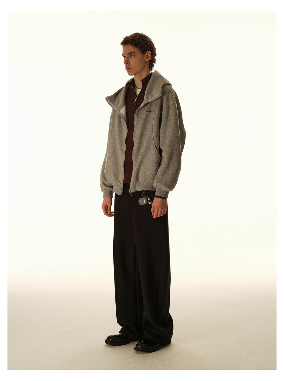 Full-length model in a gray zip-up hooded jacket and black wide-leg trousers, angled slightly to the side.
