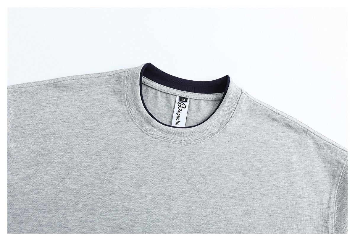 Close-up of a light gray crew-neck T-shirt with dark inner collar trim and a visible neck label.