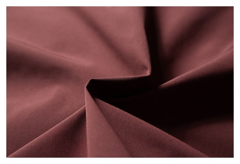 Macro view of burgundy fabric folded to show its fine surface texture.