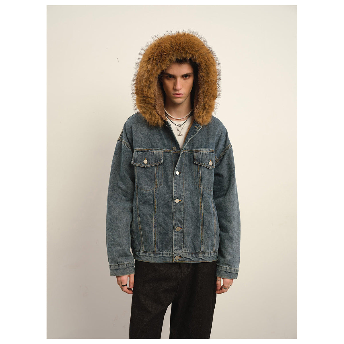 Man wearing a blue denim jacket with a large brown fur-trimmed hood, front button closure and chest pockets.