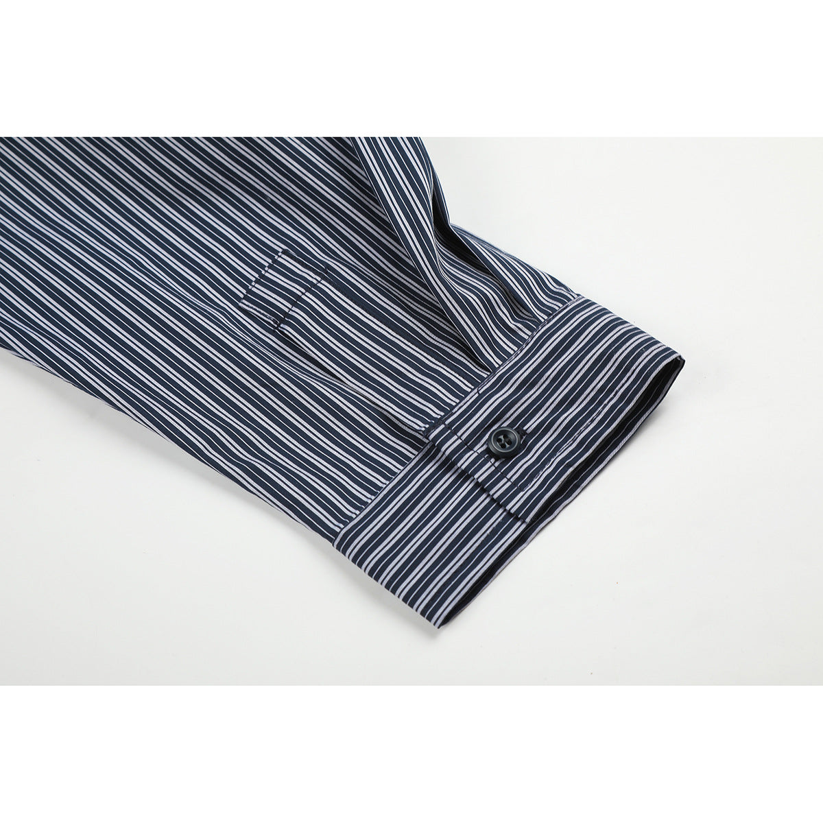 Close-up of a striped shirt sleeve and buttoned cuff.