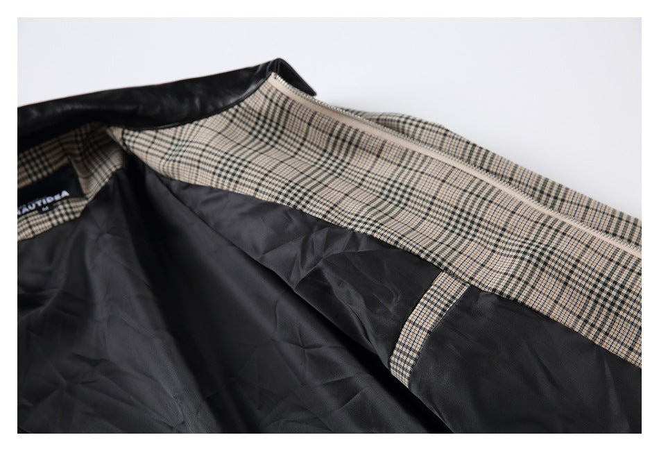 Inside of a black jacket showing dark lining, a beige plaid facing, zipper, and sewn label.