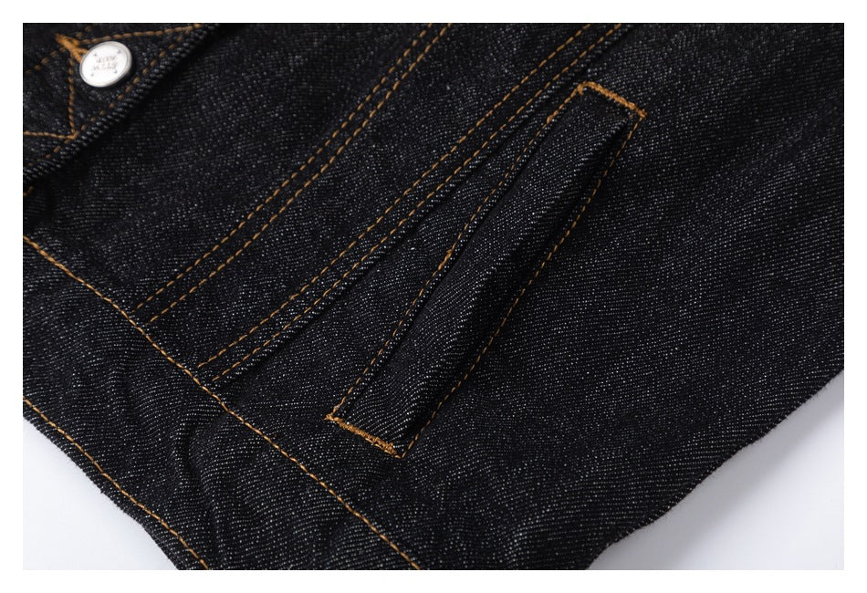 Close-up of a narrow stitched tab and seams on black denim.