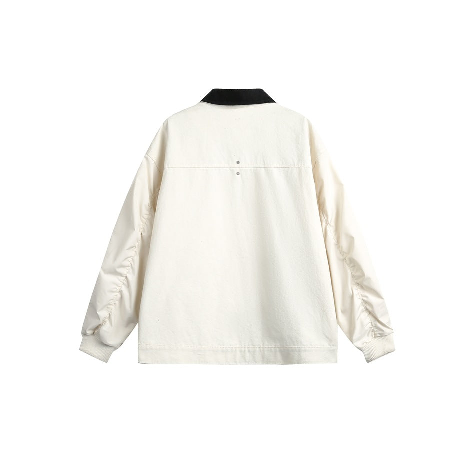 Back view of an ivory jacket with a black collar, gathered sleeves, and ribbed cuffs.