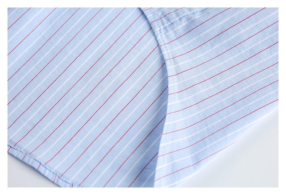 Close-up of the curved lower hem of a light blue shirt with red and white stripes.