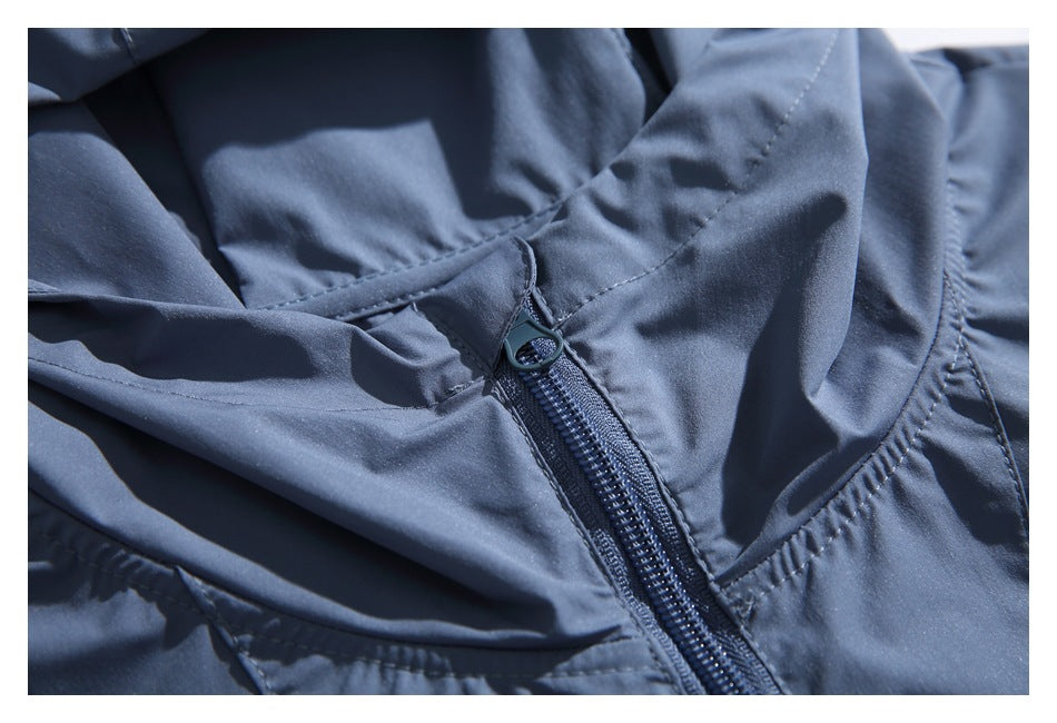 Close-up of the slate-blue jacket's zipper, hood seams, and stitching.
