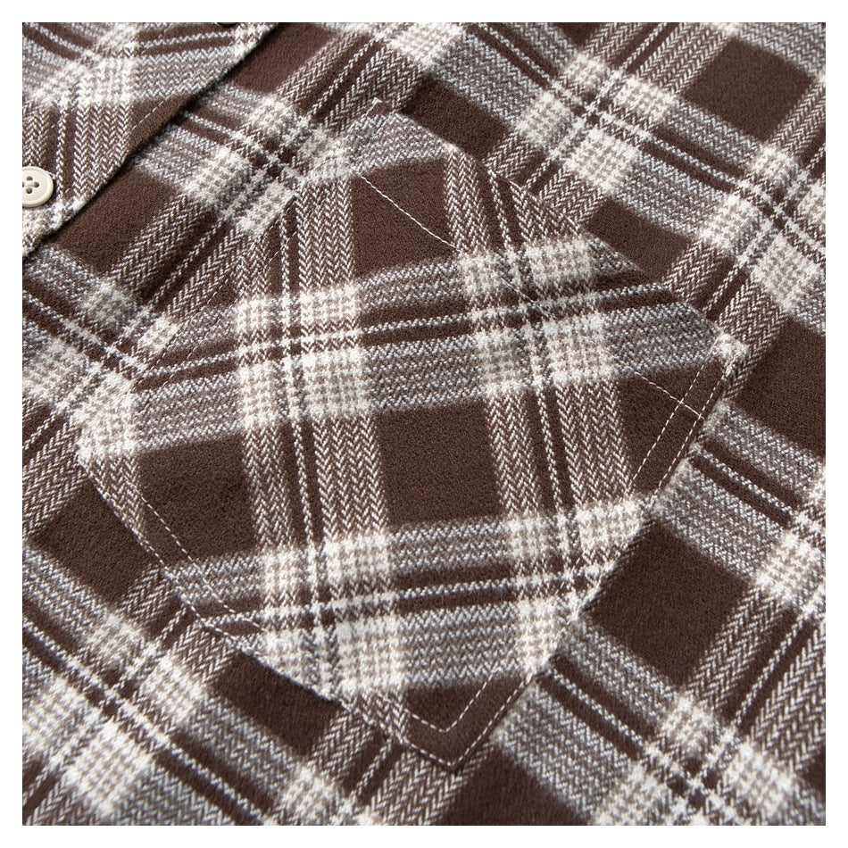 Close-up of a large chest pocket on a brown and cream plaid shirt.
