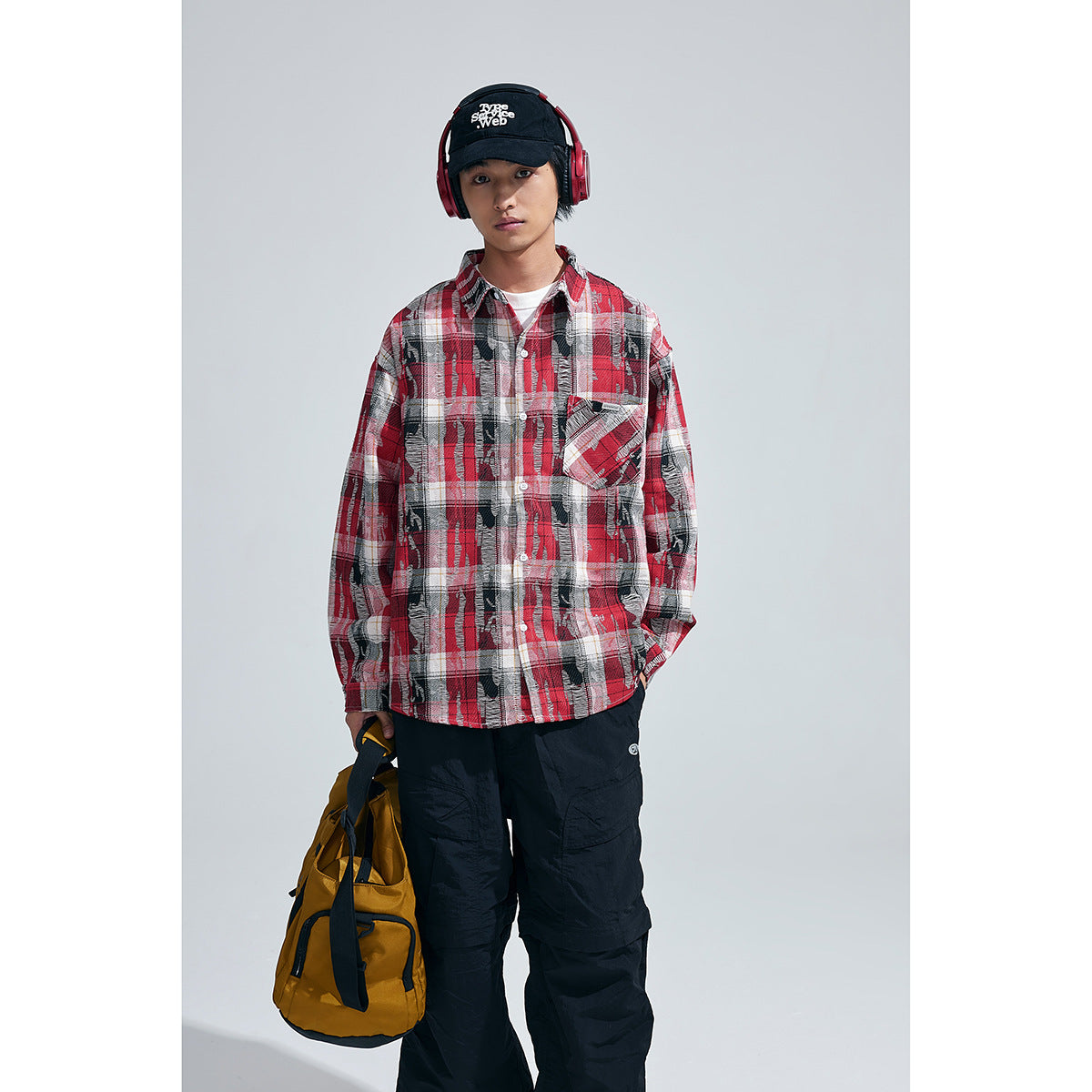 Model wearing a red, black and white plaid button-up shirt with a chest pocket, shown from the front.