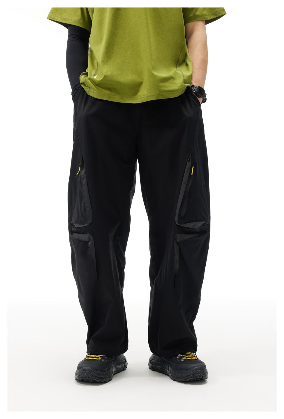 Front view of a model wearing black wide-leg cargo pants with zip pockets and large flap pockets.