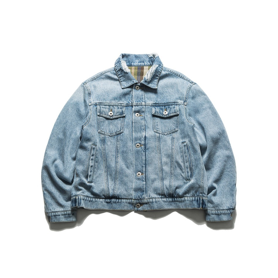 Light blue washed denim trucker jacket, front view, with chest flap pockets and frayed collar