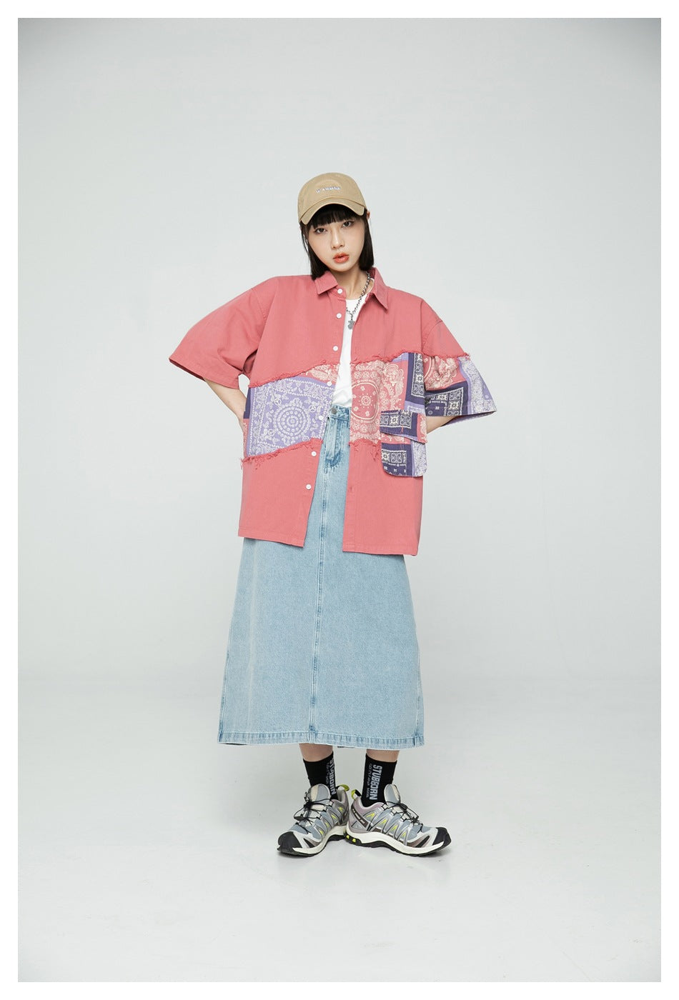 Front view of a model wearing an oversized coral shirt with purple and coral paisley patchwork panels.