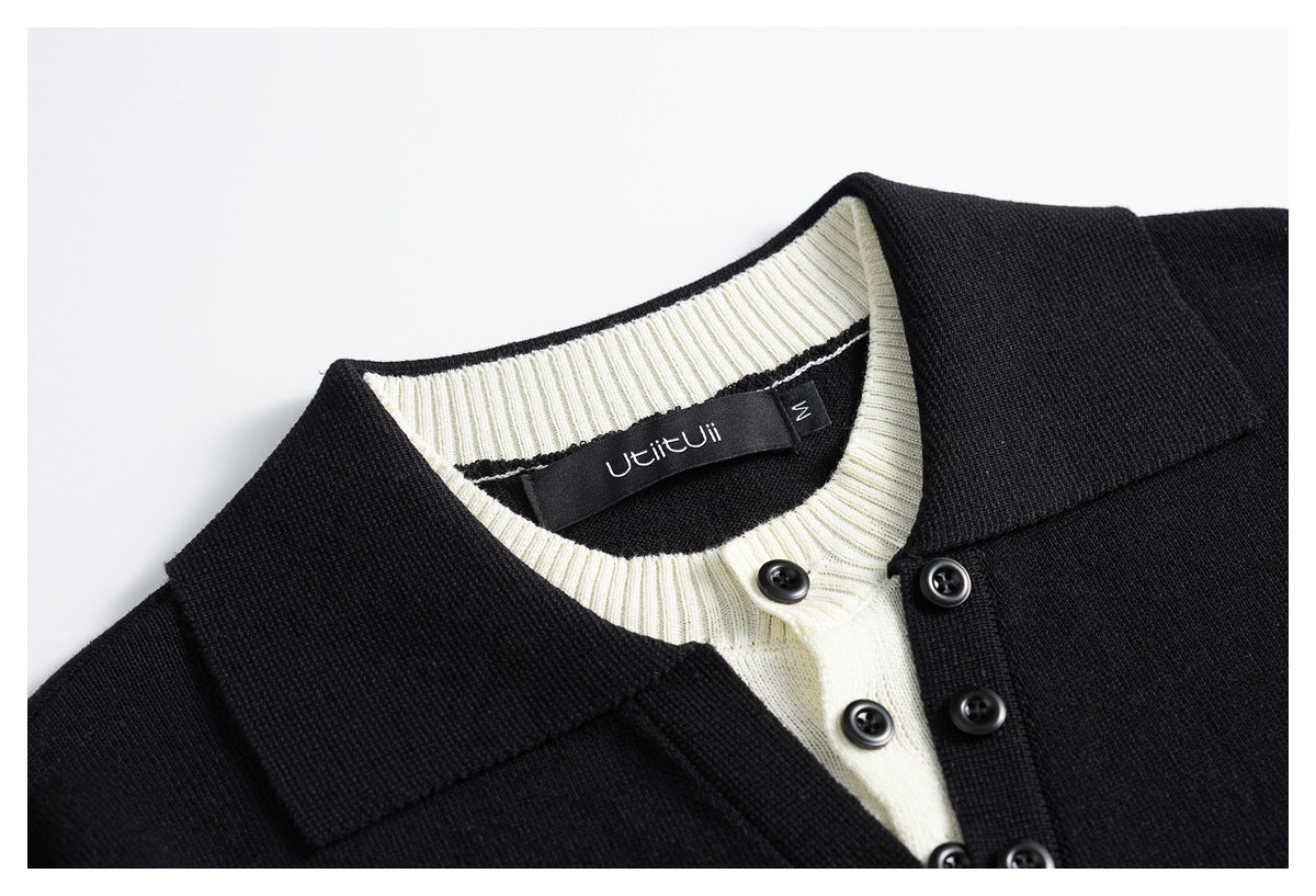 Close-up of a black cardigan collar, cream ribbed neckline, and buttoned front.