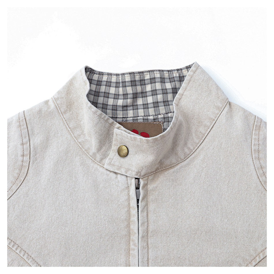 Close-up of the beige jacket's stand collar, front zipper, snap, and black-and-white plaid lining.