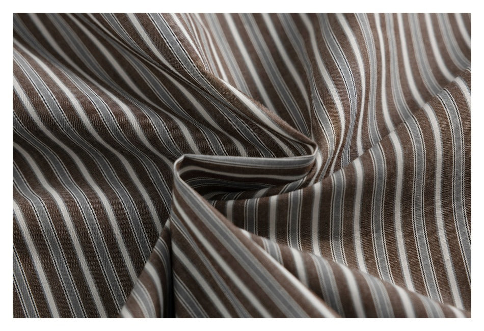 Close-up of brown and cream striped fabric draped into soft folds.