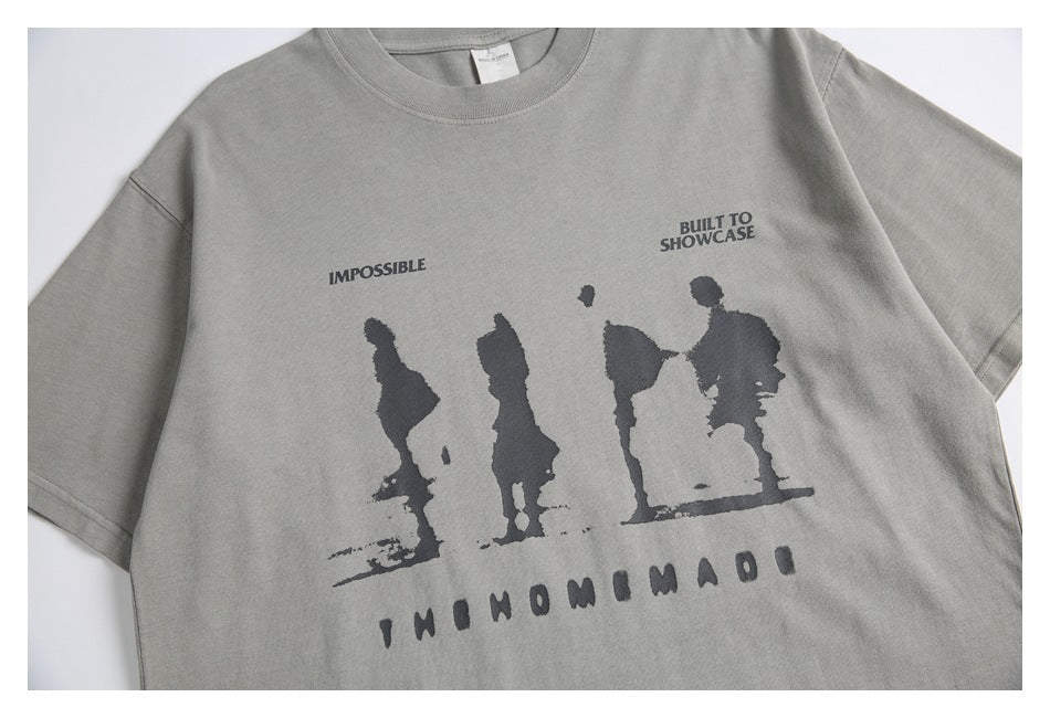 Close-up of the front graphic on a light gray T-shirt, with dark silhouettes and English lettering.