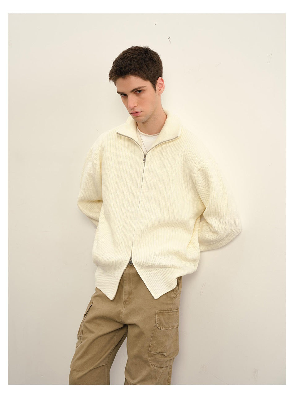 Closer view of a model wearing an ivory ribbed zip cardigan with a stand collar and tan cargo trousers.