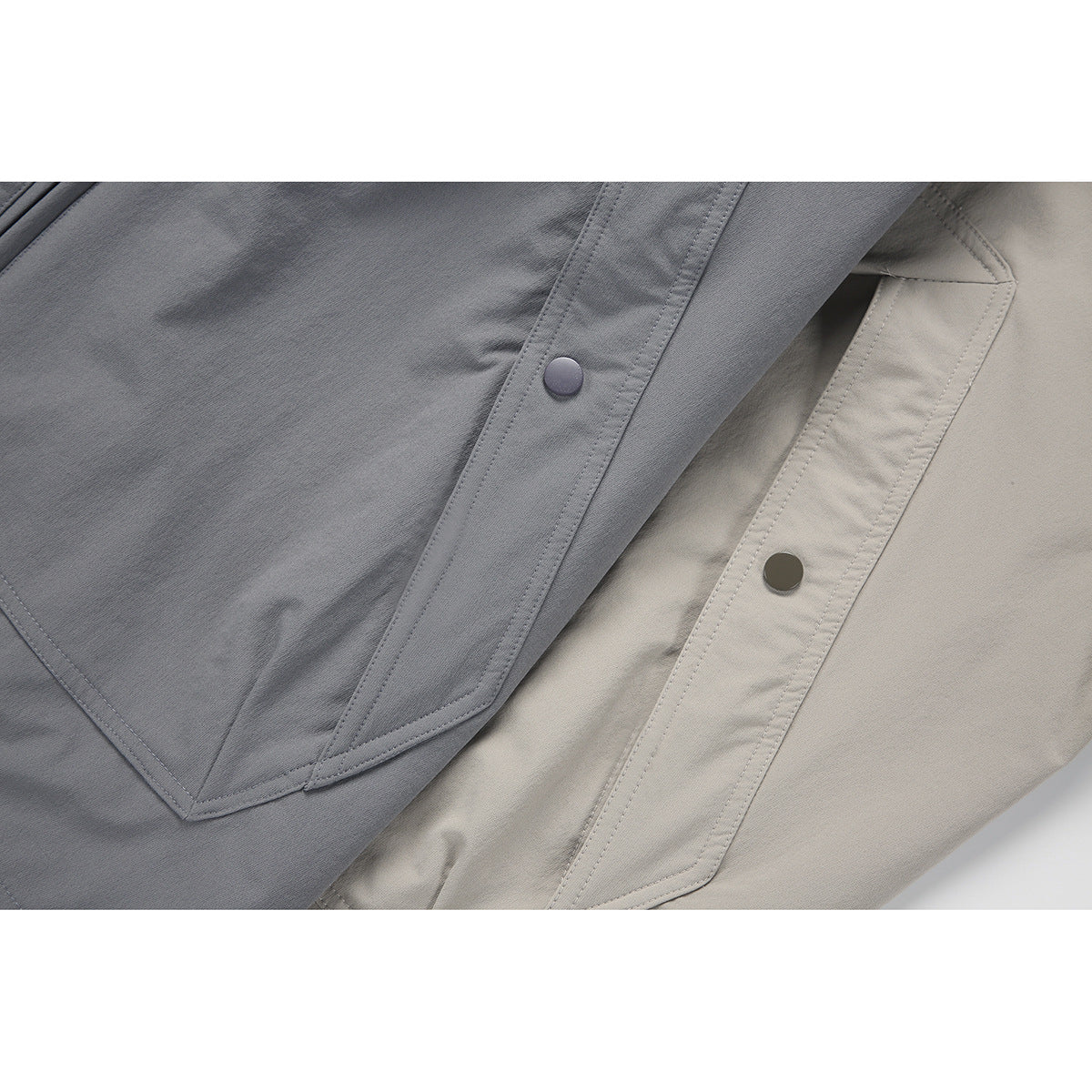 Close-up comparing angled snap pocket details on slate gray and light taupe jackets.